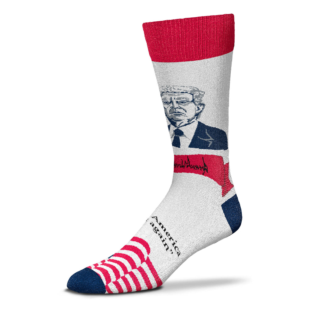 For Bare Feet Makes Patriotic Selfie Donald Trump in Red White and Blue.  President Trump is wearing a Blue Suit, White Shirt with a Blue Tie. Below in a Red bunting is President Trumps Signature. Below this is one of his signature phrases in Bold Blue Letters "Make America Great Again" On the top of Foot are The Blue Background with White Stars and the Red and White Stripes of The American Flag Waving. The Cuff is Red, the Heels and Toes are Blue.