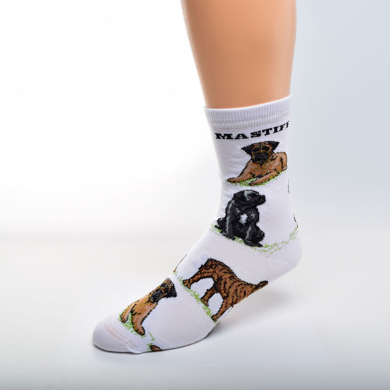 For Bare Feet Mastiff Poses Sock has a White background. Mastiff, is in Bold Black Print under the Cuff. The Poses are on Green Grass. The first Pose is an Apricot with Black Mask Mastiff Laying Down. Then a Black Mastiff with White Markings Sitting.  A Brindle Mastiff in a Stance is the Last and the pattern begins to repeat.