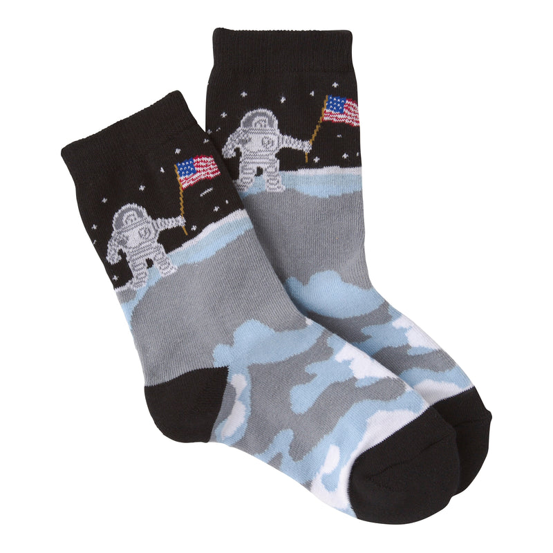 K Bell Kids American Made Man On The Moon Socks are Black Toes and Heels. The Cuffs and Top of the Sock are Black with White Stars. The Astronaut has the American Flag ready to plant on the Moons surface. The Moon is White. Light Blue and Medium Grey.