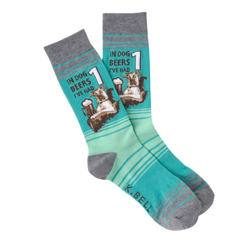K Bell Mens Dog Beers Sock is a testament to men who love their dogs and their beer!  This Sock starts on a Field of Turquoise and Azure. Then has Greys as the Cuffs,  Heels and Toes. In Bold Print reads, IN DOG BEERS I'VE HAD 1.  The Dog is sitting in a chair or sofa and has a Stein of Beer with a head on it.