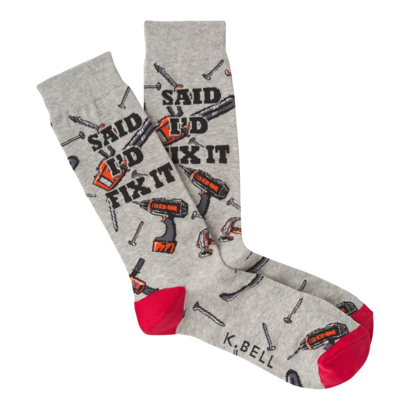 K Bell Mens Fix It Sock starts on a Grey Heather background with Red Heels and Toes. It has Nails and Screws all around. The Sock also has many Power and Hand Tools for the HandyPerson to work with while on the Job! Hammers and Saws are two.