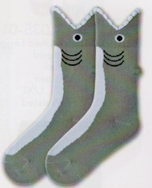 K Bell Kids Wide Mouth Shark Sock is a Grey and White background. The Grey is the top of the Shark and the White is the underbelly. The Wide Mouth is the Cuff with Puffy White Yarn for Teeth. The Eye is Black with a White Circle around it. The Gills are Black. On top is a little 3D Grey piece that works as the Top Fin.
