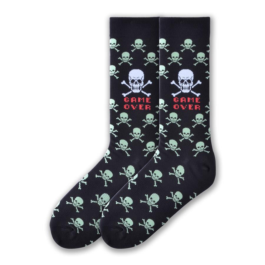 K Bell Mens Game Over is on a Black background with Green Skull and Crossbones all over. In the Center of the Crew is a Large White Skull and Crossbones with Red Words that reads, "Game Over".
