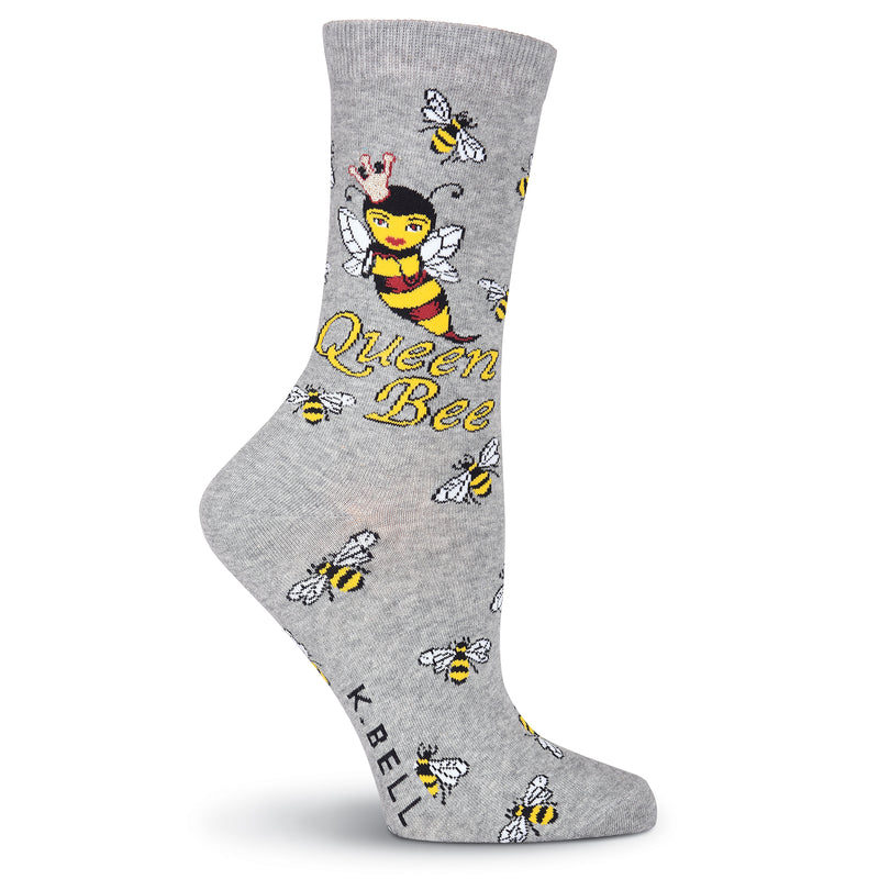 K Bell Queen Bee Sock is Grey Heather. Bees flying around, under the Cuff is the Queen Bee. Under Her reads, "Queen Bee".