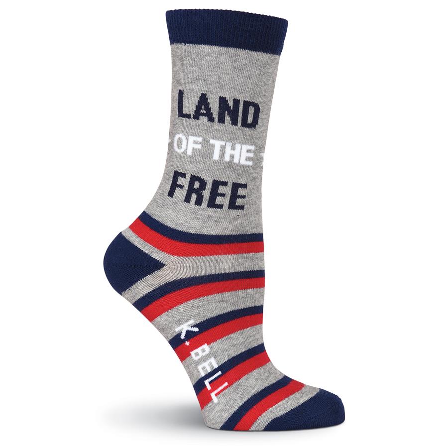 K Bell American Made Land of the Free Medium Sock starts on a Light Grey background with Navy Cuff, Heels and Toes. From the Heel to the Toes are Red and Blue Stripes. The the middle of the Grey are the Words on one Sock, "Land of the Free"