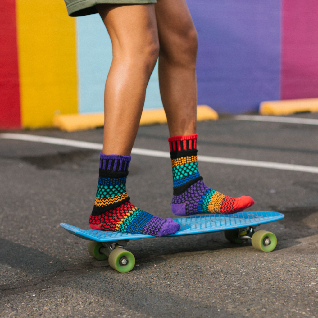 Solmate Adult Crew Gemstone Socks are being worn by this model on a Blue Skateboard.