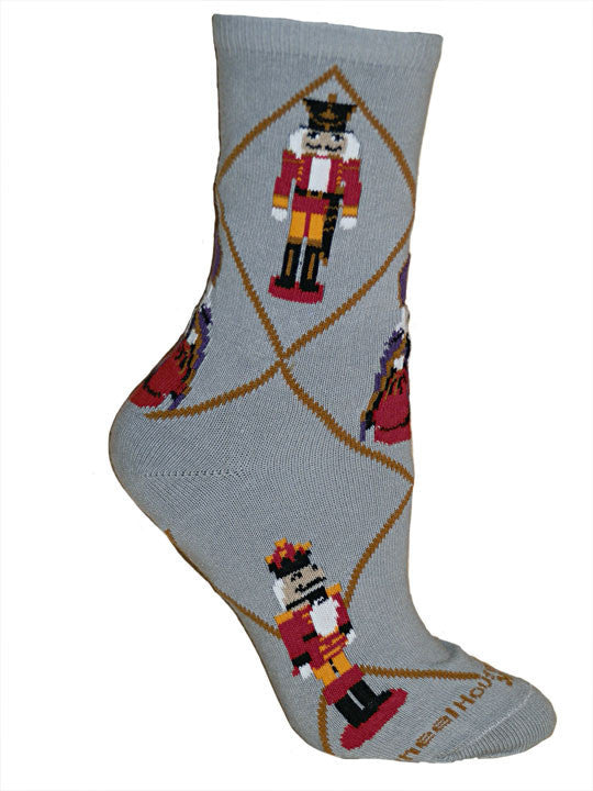 Wheel House Designs Nutcracker Sock starts on a Grey background with Mahogany Diamond Lines. The Nutcracker is Black with Red and Orange. White is the Hair, Gloves and Front on the Nutcracker.