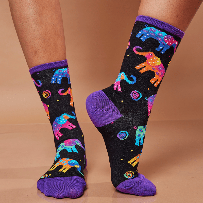 Colorful elephant-patterned socks with purple accents on a beige background