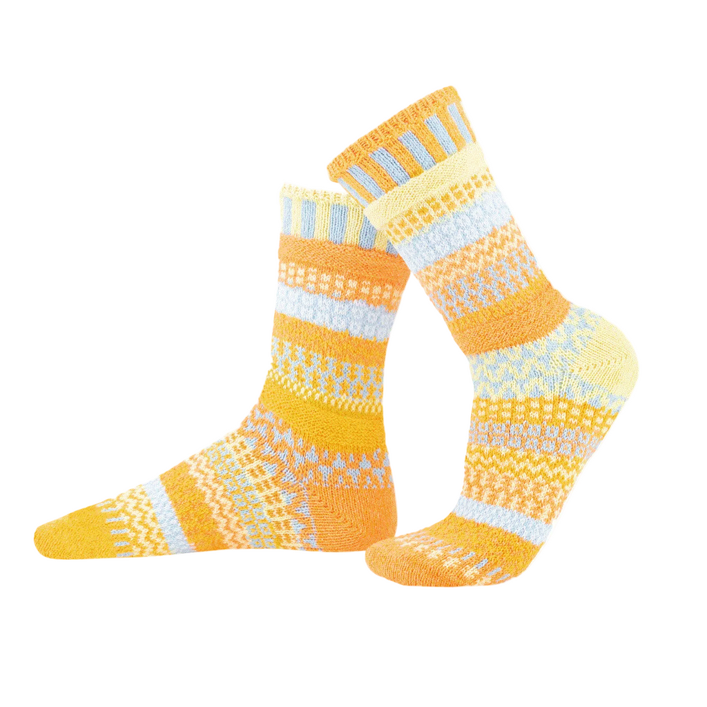 Pair of yellow and white patterned socks on a white background