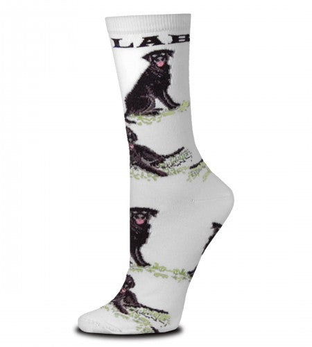 For Bare Feet Black Lab Poses Sock starts on a Bright White background.  Under the Cuff reads, "LAB" in Black Bold Print. After that are Black Labs in Poses all the way down to the Toes. All the Poses are on top of Green Grass. The Labs are Black and Dark Grey and Medium Grey for Shading and Highlights. The Eyes are Grey and Black and the Mouth is Rose. The Poses are Sitting and Laying Down.