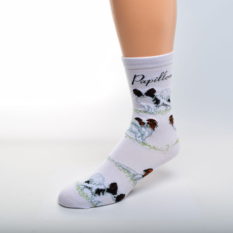 On a White background For Bare Feet Papillon Poses Sock begins. Under the Cuff reads, Papillon in Black Print. Black and White Papillons in a Stance pose are first. Then two reverse White and Red Papillons. A White and Red Papillons Laying Down is the Last Poses and the Pattern repeats.