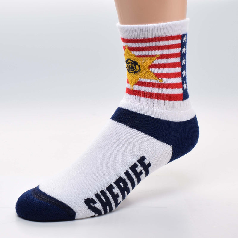 FBF Sheriff Flag Cuff Sock starts with 13 Red and White Stripes and a Navy Blue Canton with 5 pointed White Stars. The Sheriff Star Badge is Superimposed on the Flag. It is Yellow Gold with a Navy Blue Emblem in the Middle. The Sheriff's Badge is a 6 pointed Star. The Heels and Toes are Navy Blue. White makes up the Foot. In Bold print reads, "Sheriff" on both sides.