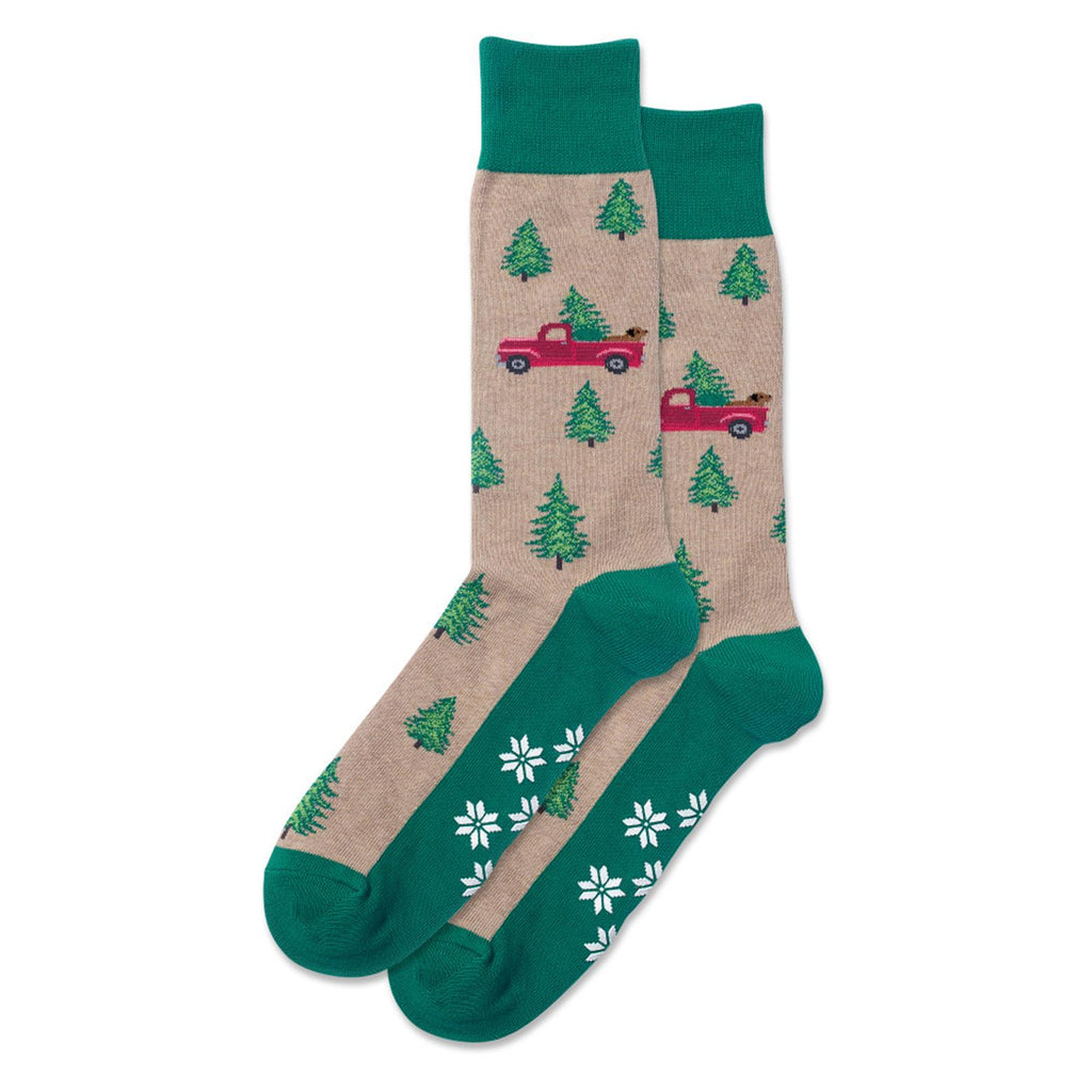 Hot Sox Mens Holiday Hemp Trucks Non Skid Socks are Hemp Beige and Christmas Green. The Truck is Bright Red with a Dog in the back with a Christmas Tree.  Christmas Trees all over.  White Poinsettias  are the Non Skids.