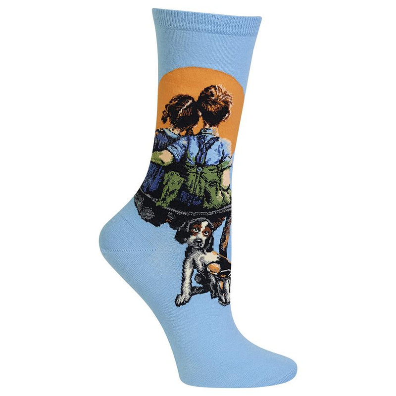Hot Sox Womens Norman Rockwell Little Spooners Sock has a smaller Cuff than the Mens Sock. It is Sky Blue background. The Boy and Girl are spooning together watching the Moon. They are sitting on a makeshift bench with a puppy waiting for them.