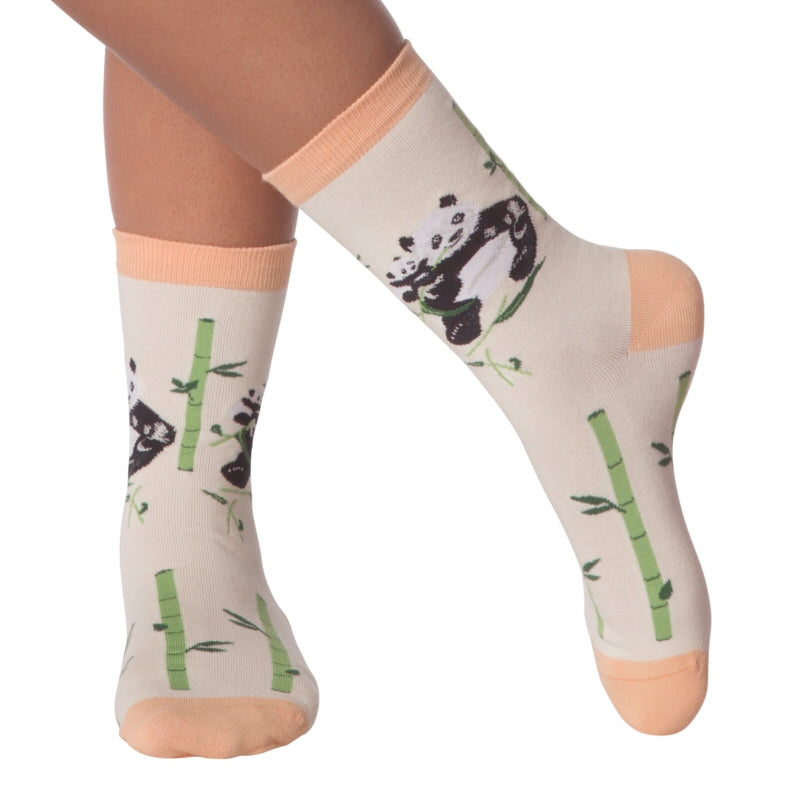 K Bell Panda Crew Sock appears on Model. Sock is Ivory with Peach Cuffs, Heels and Toes. Bamboo is Green and Dark Green Leaves. Below Cuffs are Panda and Baby Panda in Black and White.