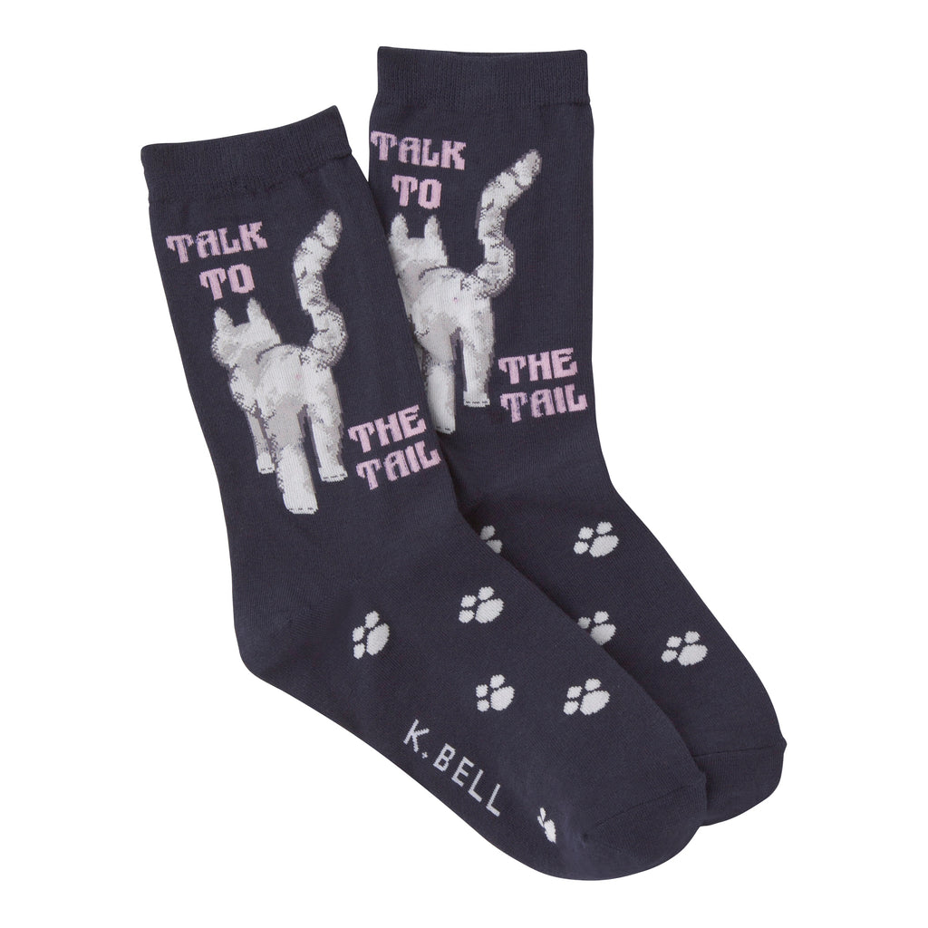 K Bell Talk to the Tail Sock is on a Navy. The Cat is Grey. Walking in the middle of words, "TALK TO THE TAIL".  Paw Prints are on the Foot.