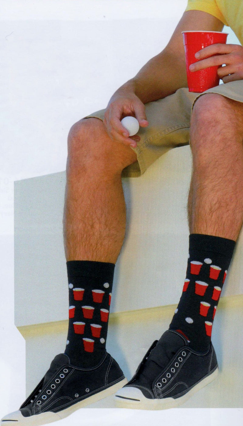 Model wearing K Bell Beer Pong Socks for Men with a drink and pong ball in hand.