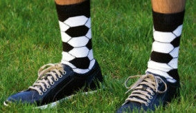Play Soccer while in Soccer Ball Socks by K Bell. Black background with White and Black making the pattern of a Soccer Ball on a Model