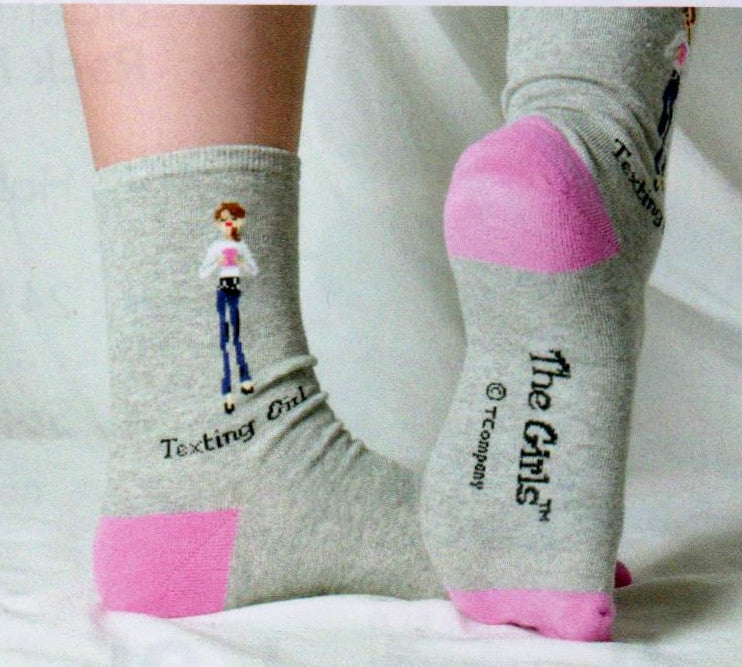 Model Wearing Texting Girls Showing the Sides and the Bottoms. The Sock has a Heather Grey background with Pink Heels and Toes. The Girl is dressed in Top and Jeans Texting on her Phone.