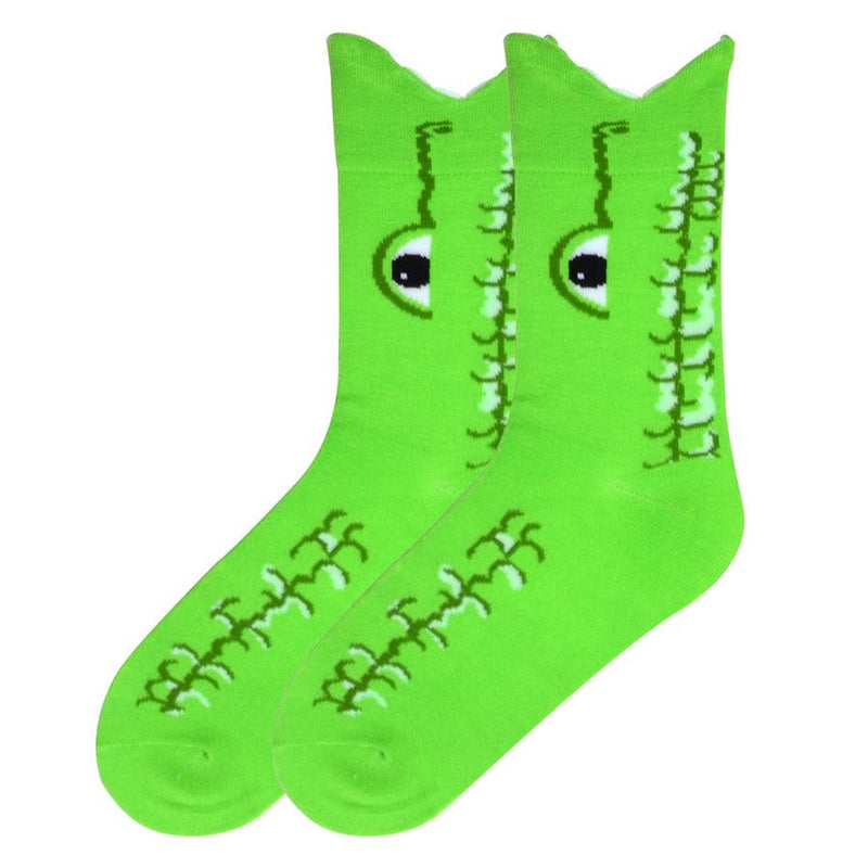 K Bell Womens Wide Mouth Alligator Sock is a Bright Green as the background color. White puffy yarn are the teeth. The eye is Black and White with Dark Green outlining also showing its snout. Dark Green and Cream also show the scaley texture of the Alligator's hide.