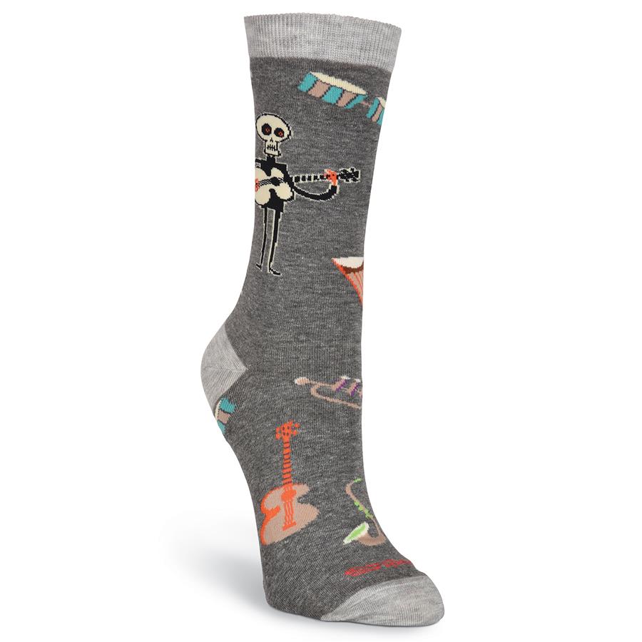 This view shows the front of K Bell Womens Shag Instruments Sock. It is Charcoal Grey and Light Grey background. The Skeleton is playing a Guitar. He is Black, Cream and Bright Orange Eyes and Hands. Other Instruments are Drums, Trumpet, and Saxophone. 