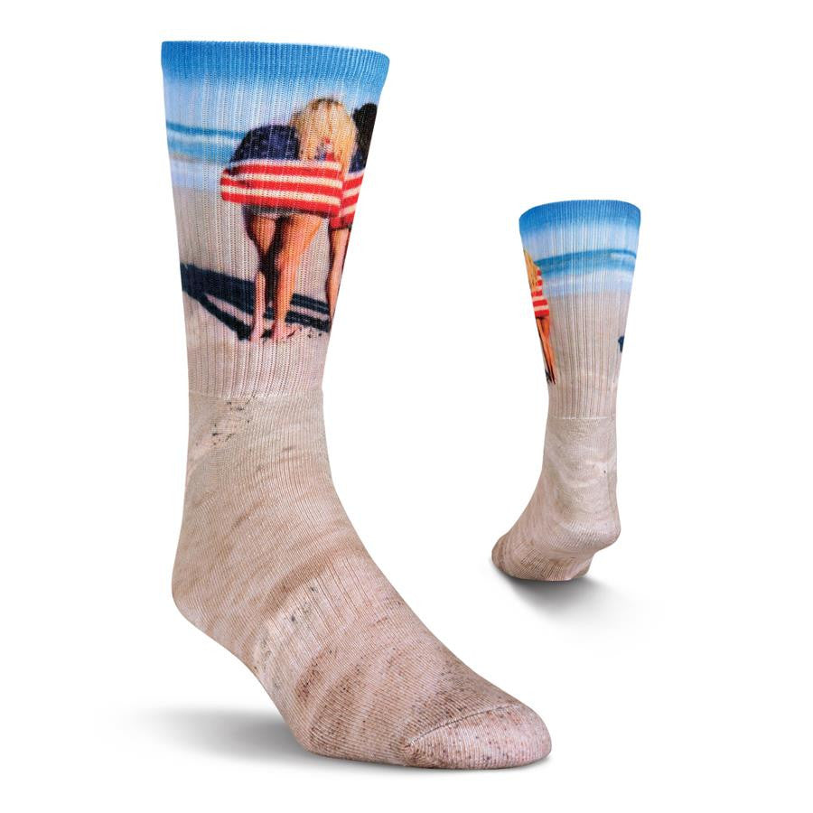 Kurb Mens Americantastic Crew Sock has Sandy Beach Colors and Blue Sky and Waves as background colors to this sock. It features 3 American Women wearing 3 American Flag Towels. This is a great way to show your Patriotic Zeal.