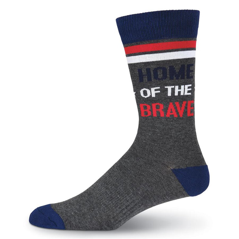 This is the second Sock to the Large pair and it starts on a Medium Grey background. The Cuff is Navy with a Red Stripe and White Stripe under it. The Heels and Toes are Navy. The Leg reads, "Home of the Brave".