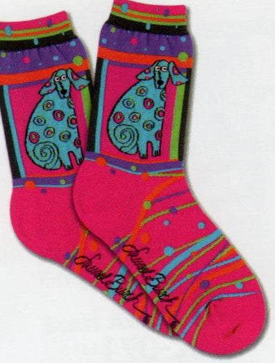 Laurel Burch Matisse Sock is on a field of Bright Magenta. The Dog is Framed and is Teal with Dots all over it. Below the Portrait are lines and Dots of Colors of the rainbow.