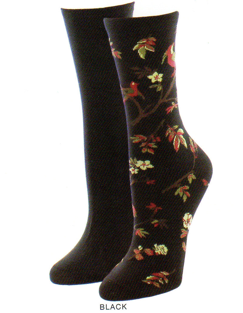 Me Moi Exotic Birds Socks 2 Pair Pack has one Black Sock and then the other is the Exotic Bird Sock. It starts with a Black background and has a Tree with Brown Branches and Red with Olive and Cream Leaves as they turn towards fall they also go Brown. The Flowers are Cream Colored with Five Petals and Maroon Stamen. The Bird is Maroon with a Cream Face and has Medium Grey and Dark Grey Feathers at the Breast and some at the Tail.