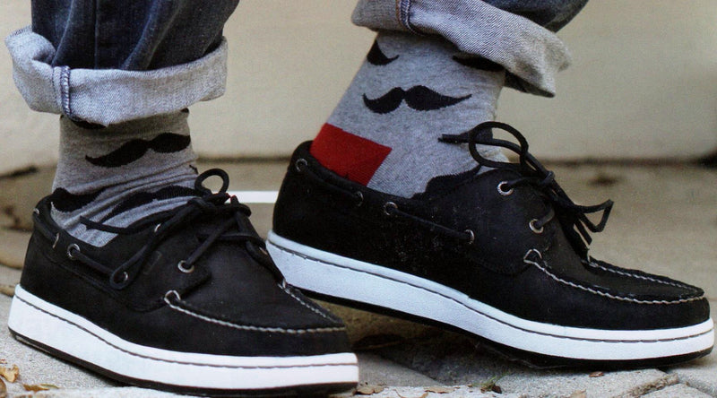 Model wearing Moustache Socks Grey background Black Moustaches Maroon Heels and Toes. 