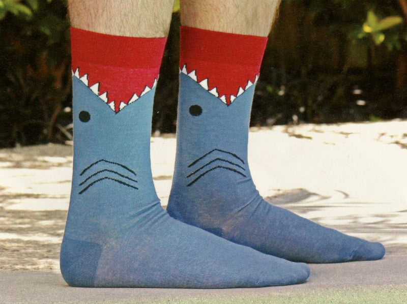 This is a Model wearing K Bell Mens Shark Sock. The Cuff is Maroon met with White and Black for Teeth. Black Eye and Gills then the rest of the Sock is Slate Blue.