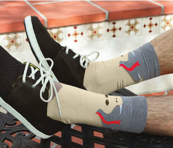 This Model is wearing the K Bell Mens Snake Sock with Black Shoes. Showing the Grey top of the Sock and the Sand color of the Snake with white Fangs and Red Tongue.