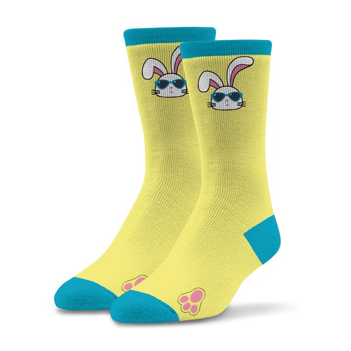 Socktastic Womens One Cool Bunny Sock begins on a Butter Yellow background with Electric Blue Cuffs, Heels and Toes. The One Cool Bunny is right under the Cuff on both sides of the Sock. He is wearing his Shades (Sun Glasses) with Electric Blue Rims. The Bunny is White with Brink Pink Ears and Nose. Black is the outline and the Mouth and Whiskers.  At the bottom of the Sock by the Toes is a fitting Graphic of a Bunny Foot! Outlined in Black and it is Brink Pink!