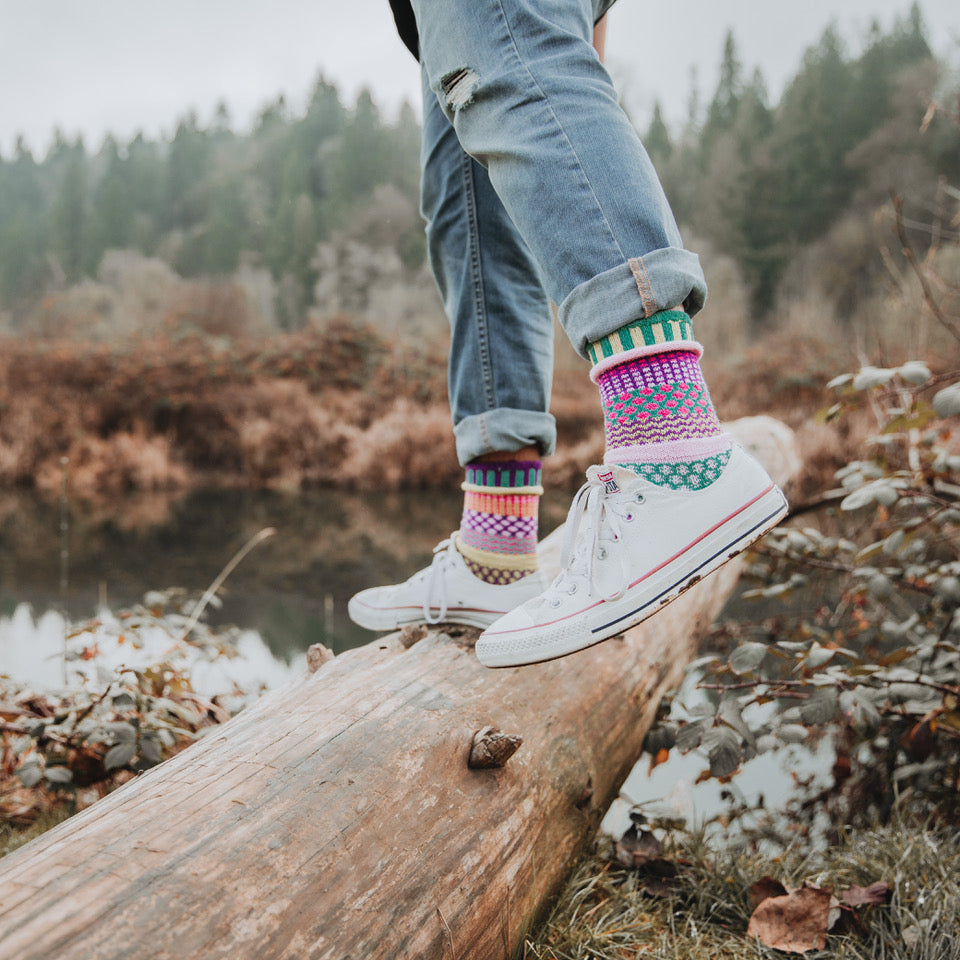 Solmate Adult Crew Sock on Model on top of a Log. 
