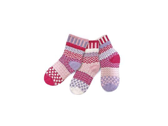Solmate Kids Crew Lovebug Sock is Mismatched. It is a Pair and a Spare. The Colors are Light Pink, Light Purple, Magenta, and White. 
