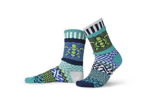 Solmate Ocean Give Back Adult Crew Sock is a Mismatched Sock. Colors are Aquamarine, Royal Blue, Beige, Lime, Green and Navy. The Ankle has a Loggerhead Turtle on it. 