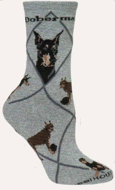 The Doberman Pinscher Dog Socks starts on a Grey background with Dark Grey Lines for Diamonds and for Doberman Pinscher. One profile shows cropped ears the other is natural ears. The poses show one in a stance, one playing with a Black Ball, and one laying down.