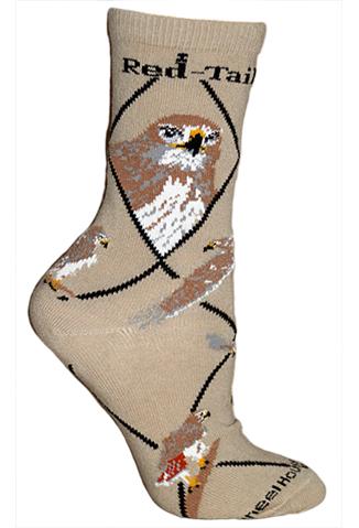Wheel House Designs Red-Tailed Hawk Sock starts on a Tan background. The Argyle pattern is Black. The Red-Tailed Hawk Portraits are Front and Profile. The Head is a mix of Raw Umber and Chamoisee. The sharp Eyes are White Black and Harvest Gold. the Nose and Beak are Harvest Gold and Black. The Breast is White with the Browns filtering. The Poses continue down the sock of in flight and looking for food
