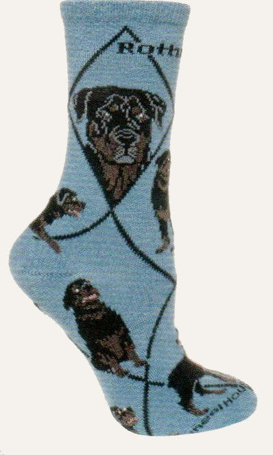 The Rottweiler Sock starts on a Blue background with Black Lines and the Bold Black Print spelling our Rottweiler. The Portraits are of a Black and Grey and Black, Dark Grey and Brown. The Poses show one Sitting, Laying Down and Standing.